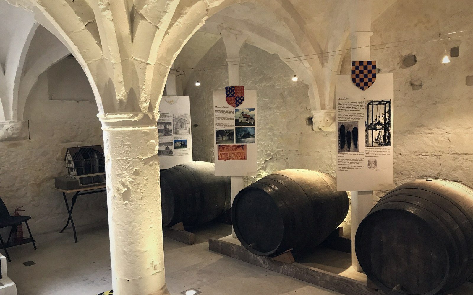 A medieval stone vaulted cellar beneath a house, ribs and springing visible